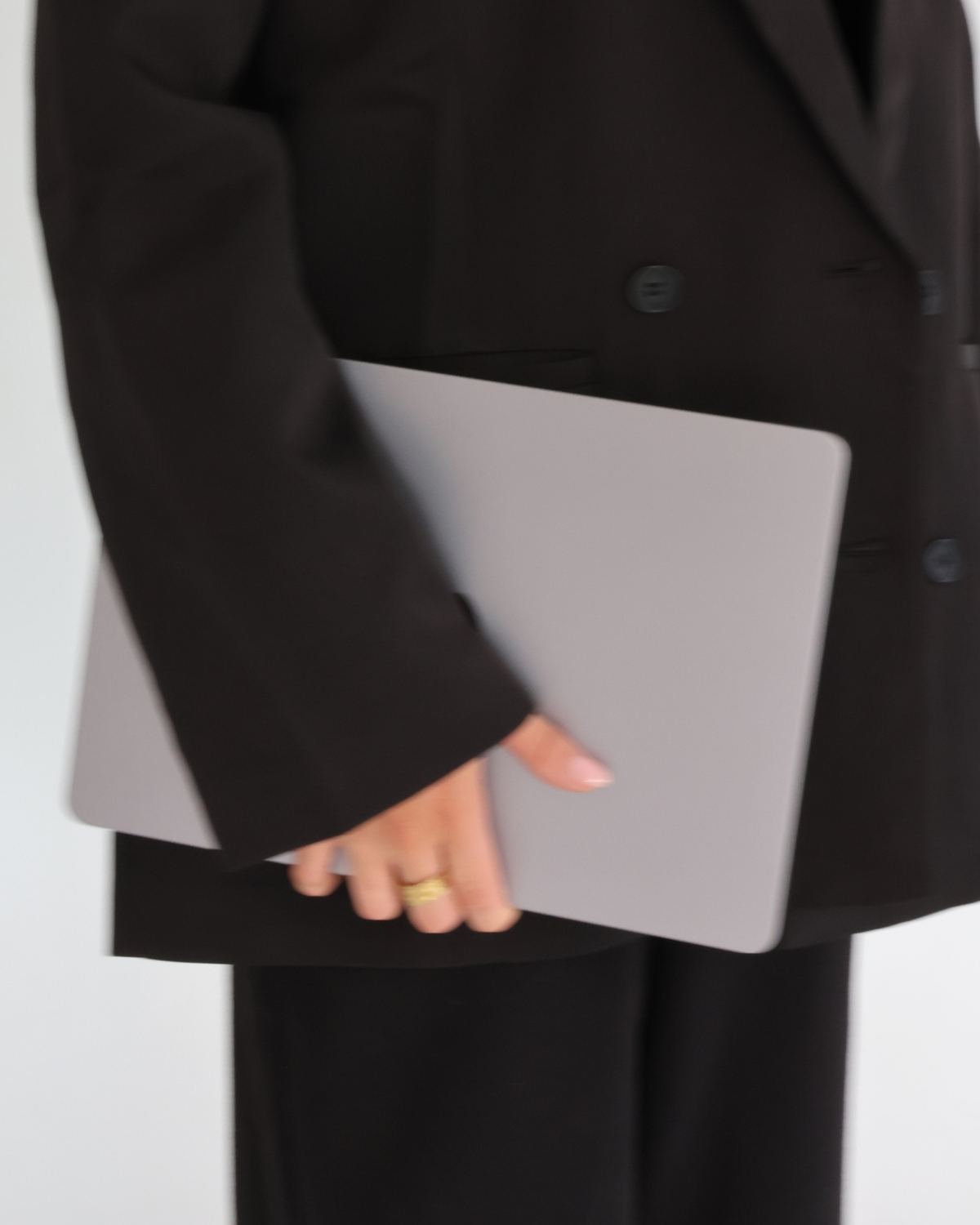 Laptop held against a black suit