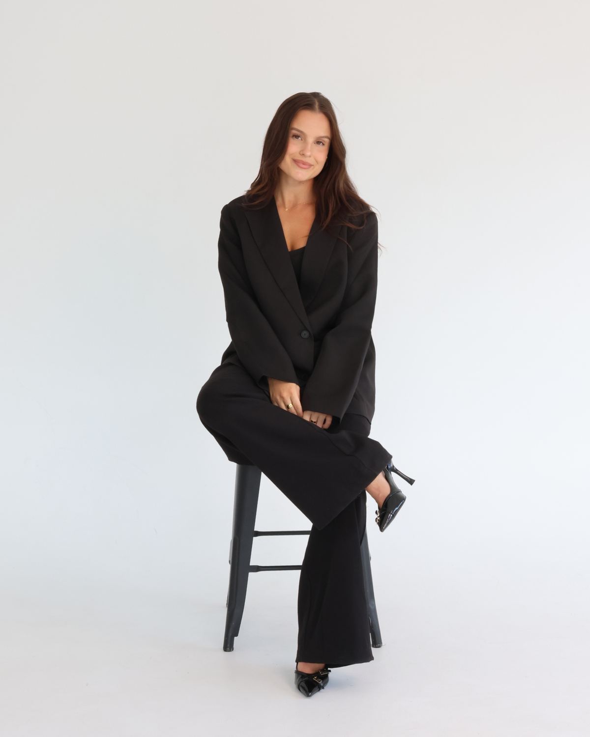 G, founder of Spread Studios, seated on a stool